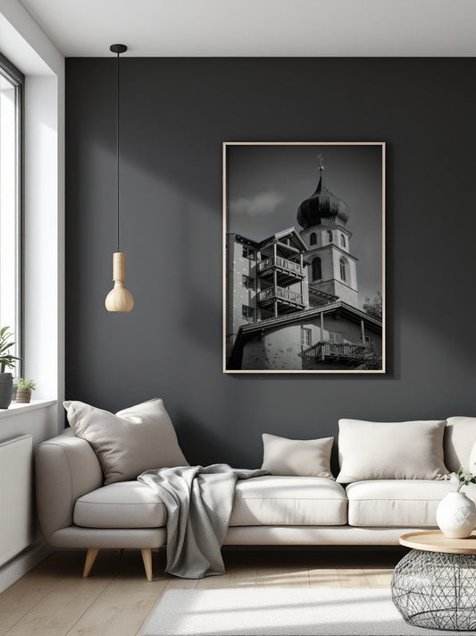 A black and white framed art print of a historic building with an onion dome, displayed on a dark gray wall above a modern light gray sofa in a styled living room.