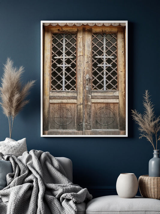 A framed wall art print depicting rustic wooden double doors with lattice windows, displayed in a styled living room setting against a dark blue wall.