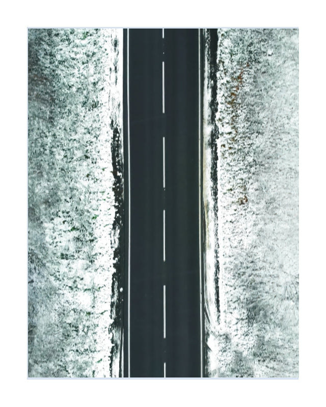 A minimalist aerial photograph of a straight black road with a dashed white centerline, flanked by textured white snowy fields on both sides, presented on a white background.