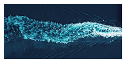 A square abstract photograph of deep blue water with a bright turquoise wave or wake cutting diagonally across the frame.