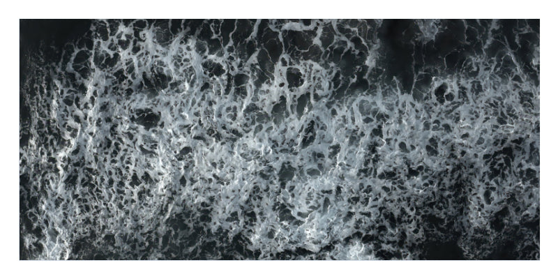 A square black and white photograph of turbulent, foamy water, likely from an aerial or satellite perspective, showing white foam against a dark water background.