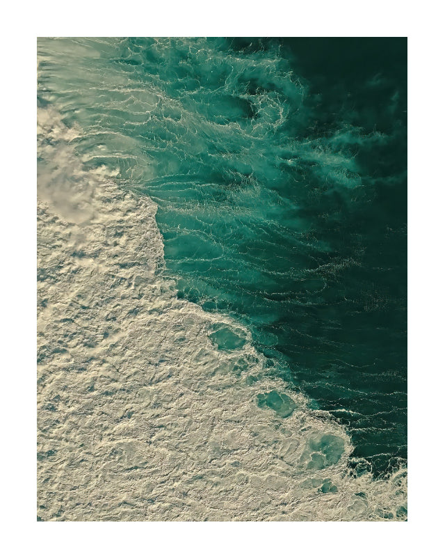 An aerial photograph of ocean waves, showing deep teal water and white sea foam in a square print with a white border.
