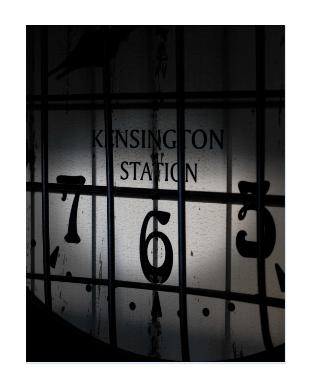 A square art print featuring a moody, high-contrast photograph of a vintage clock face at Kensington Station, with the words 'KENSINGTON STATION' and numbers obscured by dark bars and shadows.