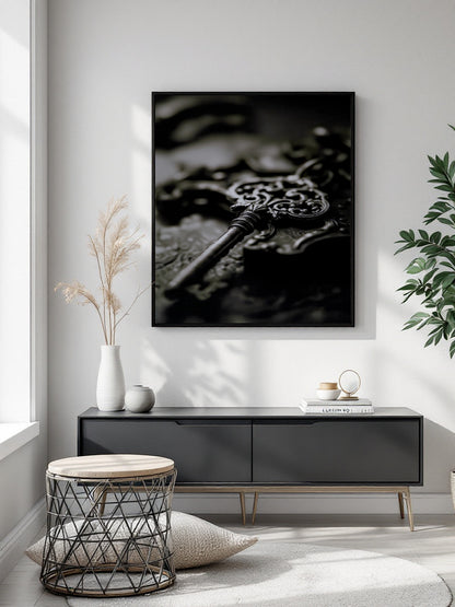A black and white framed wall art print depicting an ornate antique key, displayed in a modern living room setting above a dark gray sideboard.