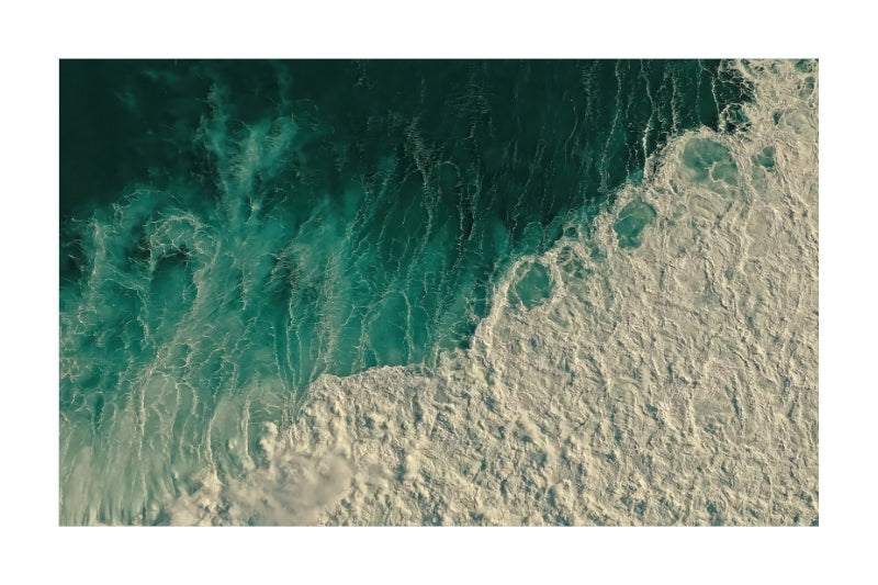 An aerial photograph of ocean waves, showing deep teal water transitioning into white sea foam, presented as a square art print with a white border.
