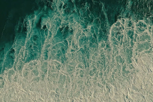 Aerial view of ocean waves with turquoise water and white sea foam, filling the entire frame.