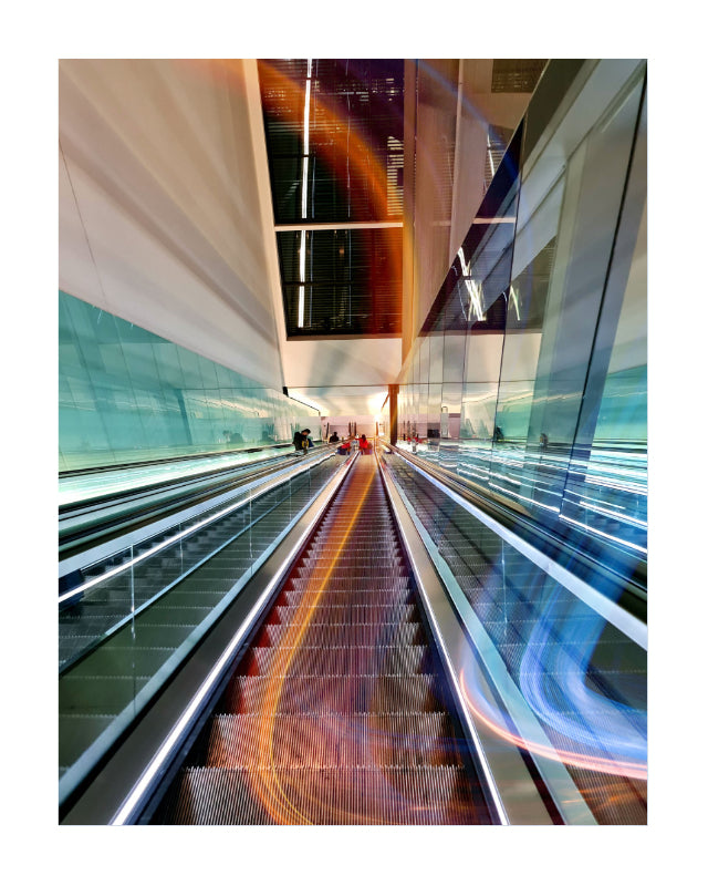 A vertical art print depicting a modern escalator system in a sleek, contemporary building with glass walls and light trails.