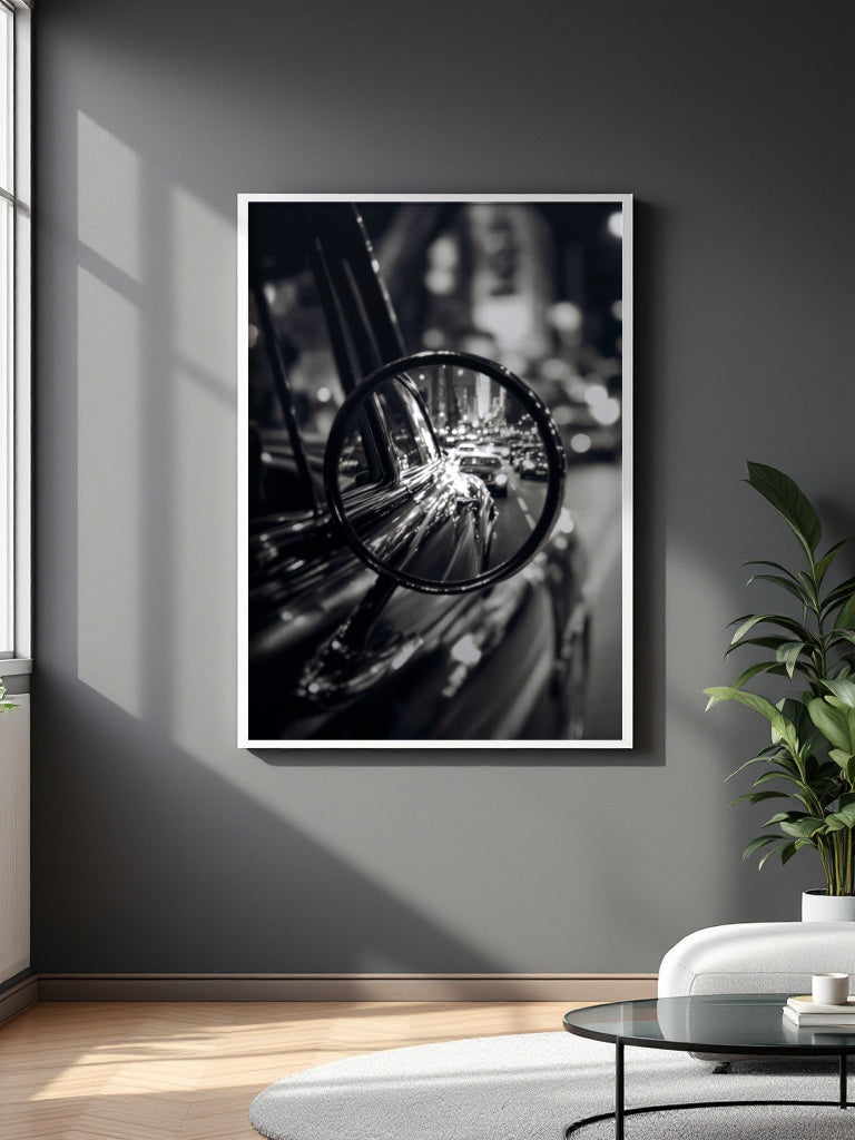 A framed black and white art print depicting a close-up of a bicycle wheel and metallic components, displayed on a dark gray wall in a modern living room setting.