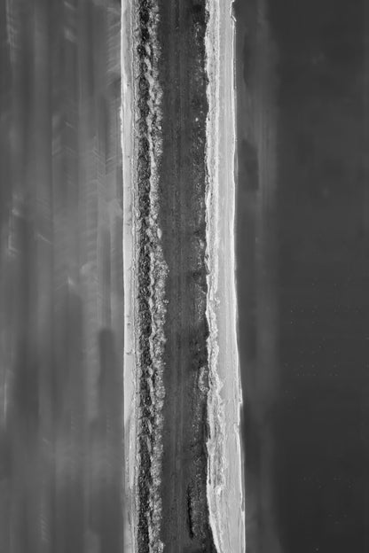 A square black and white abstract painting featuring a vertical textured band of gray, white, and black tones flanked by blurred gray brushstrokes.