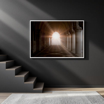 A framed wall art print depicting a sunlit archway corridor with columns, displayed on a dark gray wall above a staircase in a modern interior setting.