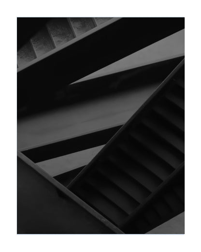 A black and white architectural photograph of intersecting concrete beams, louvers, and stair-like slats, presented as a square print with a white border.
