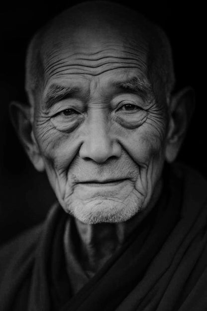 Black and white close-up portrait of an elderly man with deeply wrinkled skin, wearing dark robes against a dark background.