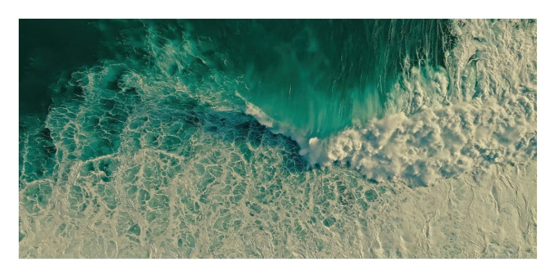 Aerial view of turquoise ocean waves breaking with white sea foam, shown within a white border.