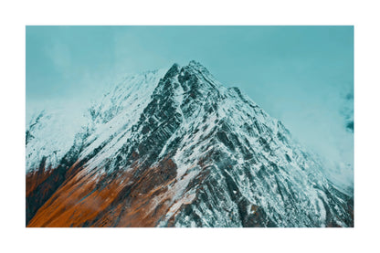 A square art print or photo of a snow-covered mountain peak with a turquoise sky, centered on a white background.