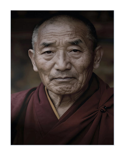 A portrait print of an elderly Buddhist monk with deep wrinkles, wearing traditional maroon robes, shown against a dark background with a white border.