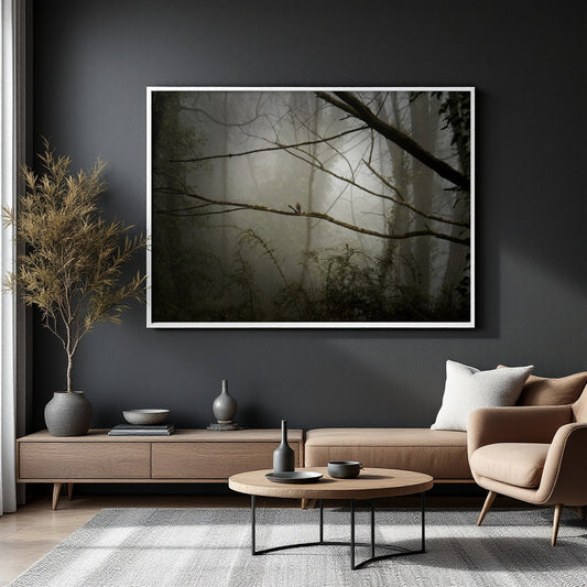A large framed wall art print depicting a misty forest with bare tree branches, displayed on a dark charcoal wall above a modern living room setup with a sofa, coffee table, and dried plant.