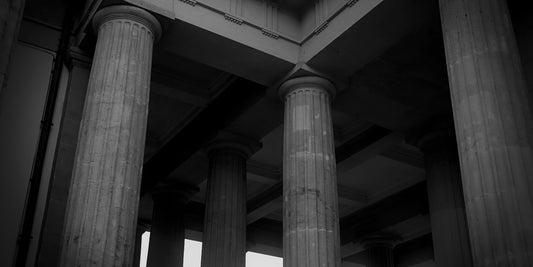 Black and white photograph of classical stone columns supporting a grand architectural structure.