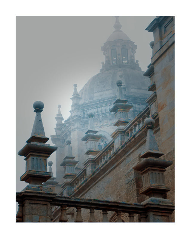 A moody architectural photograph of a grand domed cathedral or historic building shrouded in mist, framed by stone balustrades and columns in the foreground.