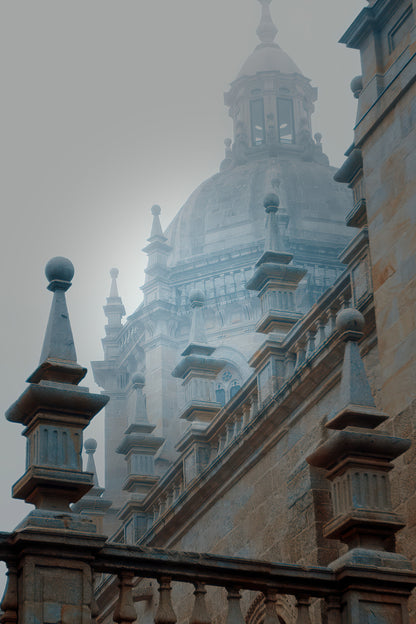 Foggy architectural photograph of a domed historic building with stone balustrades and spires in soft gray tones.