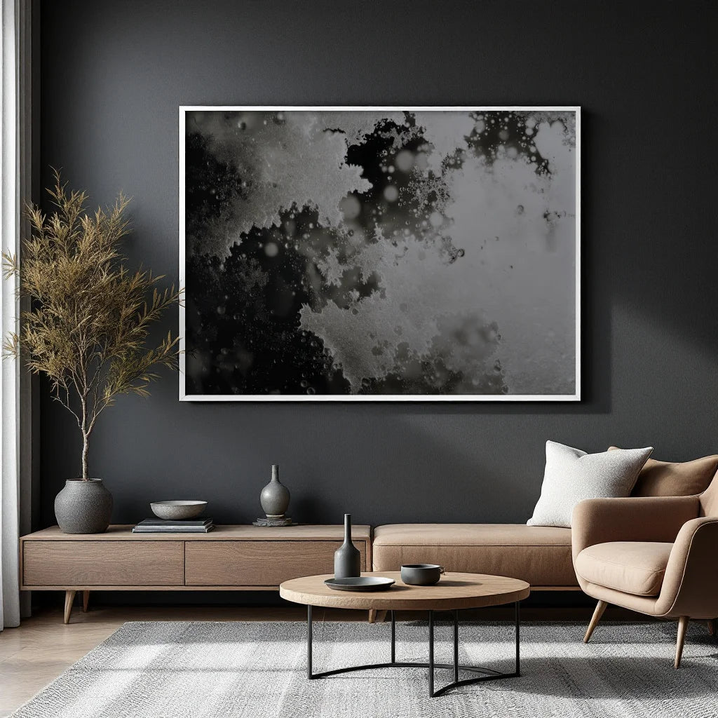 A large framed abstract black and white print hangs on a dark charcoal wall above a modern living room setup with a sofa, armchair, coffee table, and dried plant.