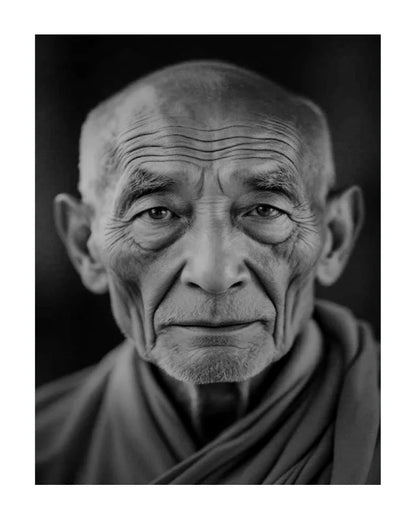 A black and white close-up portrait of an elderly man with deeply wrinkled skin and a calm, direct gaze, wearing draped robes against a dark background.