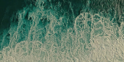 Aerial view of ocean waves with turquoise water and white sea foam, filling the entire frame.