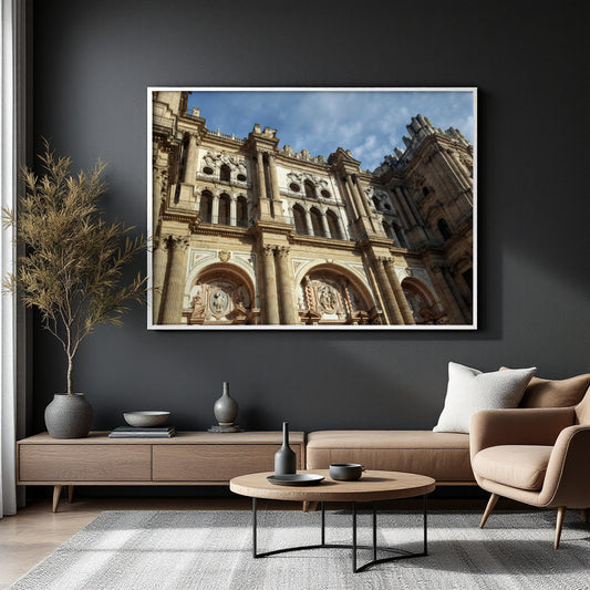 A framed art print of a grand historic cathedral facade is displayed on a dark charcoal wall in a modern living room setting with a sofa, armchair, and coffee table.