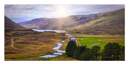 A scenic landscape print showing a winding river through a green valley with hills and mountains in the background under a cloudy sky with bright sunlight.